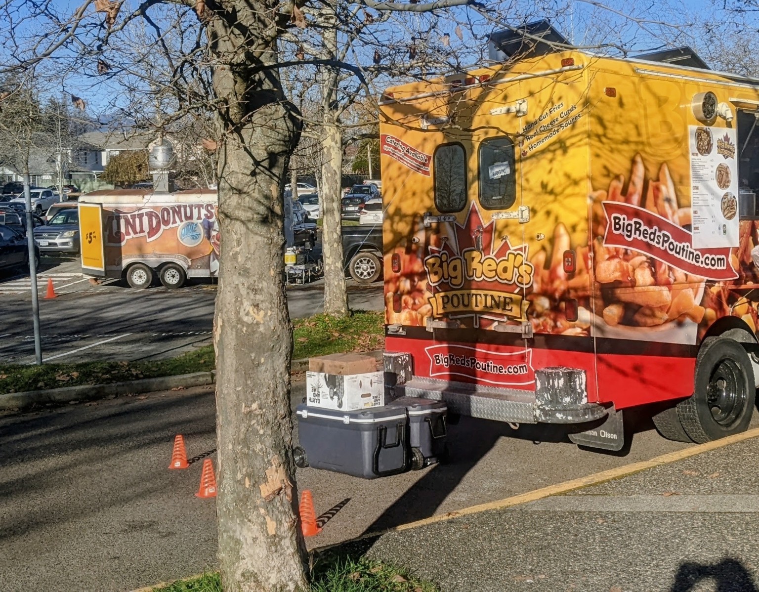 Big Red’s Poutine food truck and a mini doughnut trailer outside at the fair